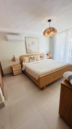 a bedroom with a large bed and a chandelier at Xanadu Casa De La Playa in Puerto Plata