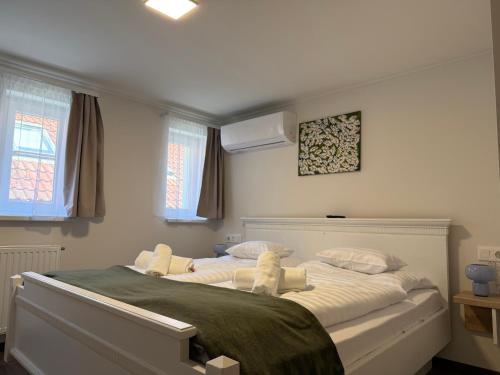 a bedroom with a large white bed with two pillows at Oliva Apartman in Bük