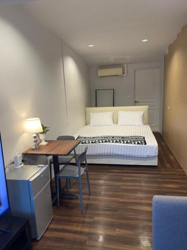a bedroom with a bed and a table with a desk at Hidden courtyard in Ban Bang Phun