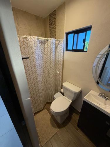 a bathroom with a toilet and a sink at Casa Cielo del Mar in Ciudad Madero