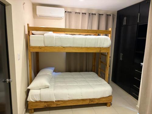 two bunk beds in a room with white sheets at Casa Cielo del Mar in Ciudad Madero