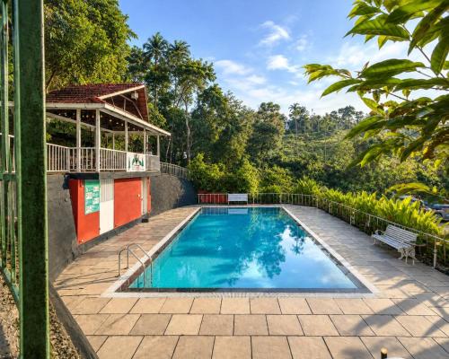 an outdoor swimming pool with a gazebo at T Hill Vythiri Pool Resort in Vythiri