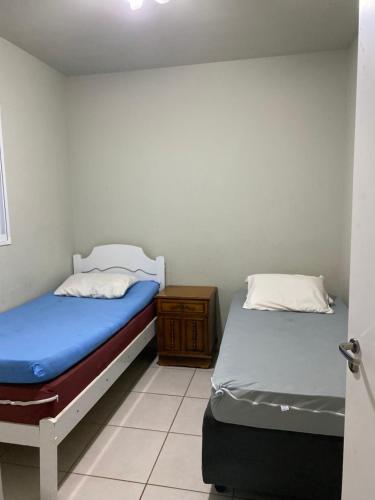 two beds in a small room withthritisthritisthritisthritisthritisthritisthritisthritisthritis at Espaço Vida Nova in Lins