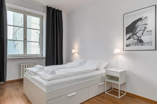 a white bedroom with a bed and a window at Quiet luxury at the Royal Route in Warsaw in Warsaw