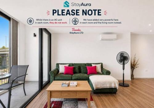 a living room with a green couch and pink pillows at Duplex 2BR Flat with Parking Near Excellent Transport Links By Stay Aura Short Term Lets Brentford in Brentford