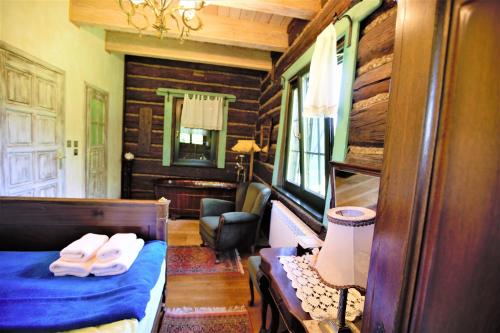 a bedroom with a bed and a chair in a room at Domy Konesera in Trzcin