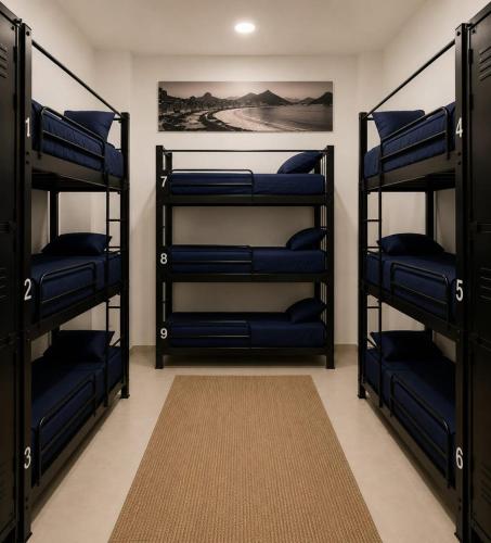 a room with three bunk beds with blue pillows at Copacabana Rooms & Hostel in Rio de Janeiro