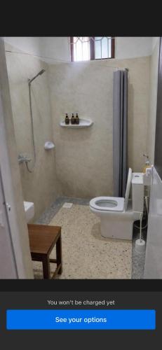 a bathroom with a shower and a toilet and a sink at Gavana House in Mfumbwi