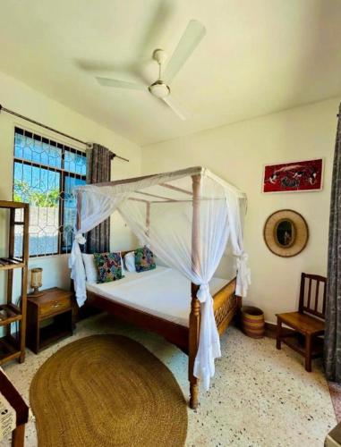 a bedroom with a bed with a canopy at Gavana House in Mfumbwi