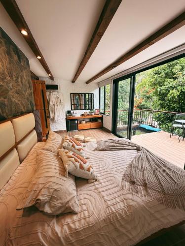 a large bed in a room with a large window at Glamping La Cima in San Gil
