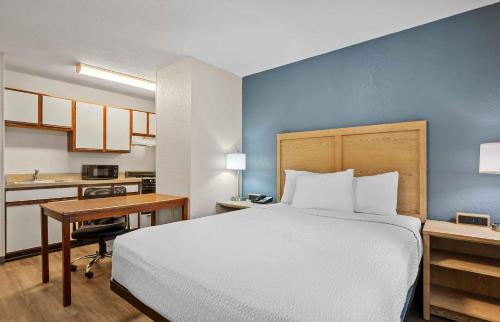 a bedroom with a bed and a desk and a kitchen at Extended Stay America Suites - Fort Wayne - North in Fort Wayne