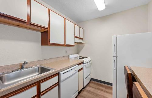 a small kitchen with a sink and a refrigerator at Extended Stay America Suites - Fort Wayne - North in Fort Wayne
