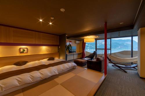 a bedroom with a bed and a hammock in a room at Inatori Akao Hotel in Higashiizu