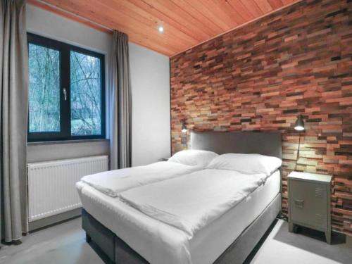 a bedroom with a large bed in a brick wall at Seeblick am Pressegger See in Lake Pressegg
