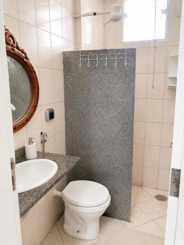 a bathroom with a toilet and a sink at Bela vista a beira mar in Marataizes