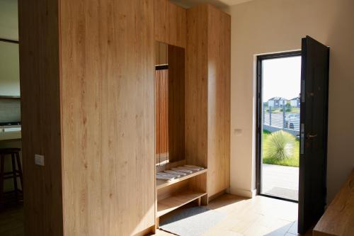 a room with wooden walls and a door with a window at Banya Villa Bucuresti sauna jacuzzi piscina spa in Gulia