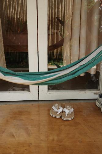 a pair of shoes in front of a window with a hammock at Verde Bungalows Siargao in General Luna