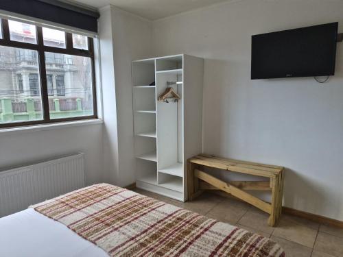 a bedroom with a bed and a tv on a wall at Apart Hotel Endurance in Punta Arenas