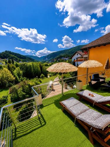a patio with chairs and umbrellas in a yard at Lola's House in Jajce