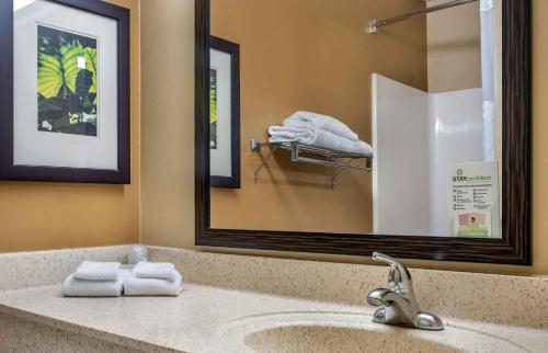 a bathroom with a sink with a mirror and towels at Extended Stay America Select Suites - Jacksonville - Baymeadows in Sunbeam