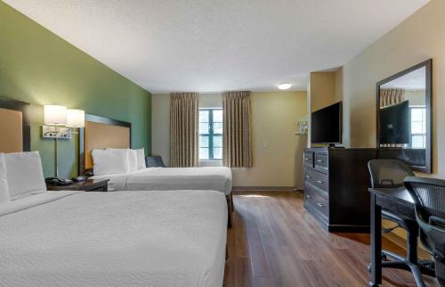 a hotel room with two beds and a flat screen tv at Extended Stay America Select Suites - Jacksonville - Baymeadows in Sunbeam