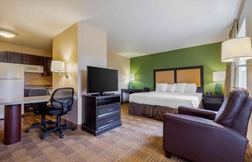 a hotel room with a bed and a desk with a television at Extended Stay America Suites - Columbia - Northwest Harbison in Harbison