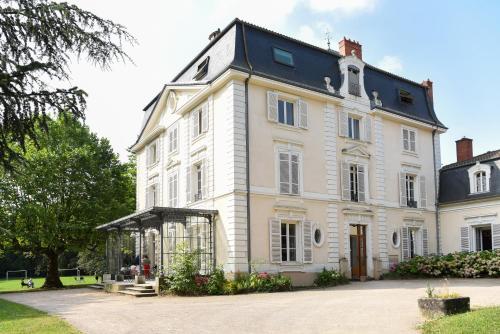 uma grande casa branca com um gazebo em frente em Hôtel Valpré em Écully