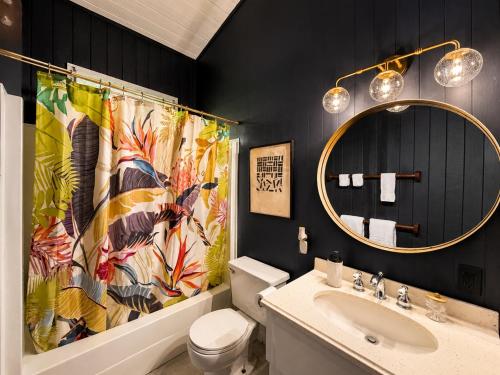 a bathroom with a sink and a shower curtain at Tiki Treehouse in Keaau