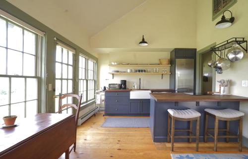 a kitchen with blue cabinets and a table and chairs at Whitford House Cottage in Addison