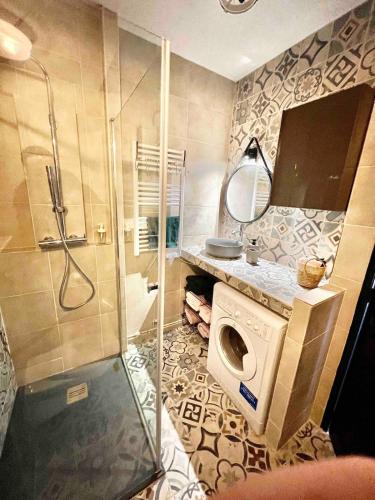 a bathroom with a shower and a washing machine at Cocon entre centre ville autoroute in Reims