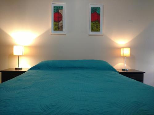 a bedroom with a green bed and two lamps at El Dorado San Juan in San Juan