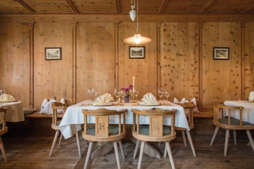 a dining room with a table and chairs and wooden walls at Alpenromantik-Hotel Wirlerhof in Galtür