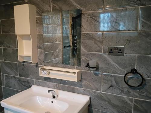 a bathroom with a sink and a mirror at Fairview Executive Suites in Bawalishi