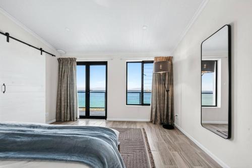 a bedroom with a bed and a view of the ocean at The Tide & Seek House in Cape Town