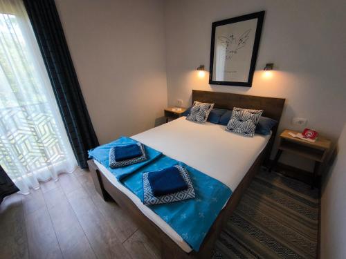 a bedroom with a bed with blue sheets and a window at B&B Hidden gem Blagaj in Blagaj