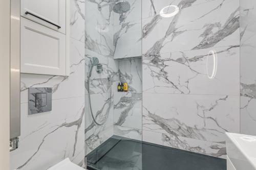 a bathroom with a shower with marble walls at Quiet luxury at the Royal Route in Warsaw in Warsaw