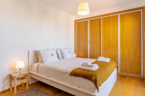 a bedroom with a bed with towels on it at Jardins Do Oceano Ii Modern Stay Near Beach in Caniço
