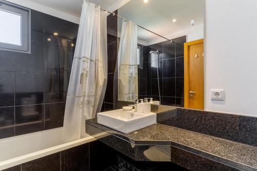a bathroom with a sink and a shower at Jardins Do Oceano Ii Modern Stay Near Beach in Caniço