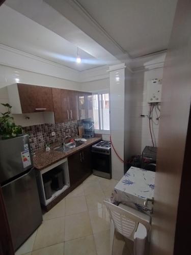a kitchen with a refrigerator and a sink and a table at Comp al Farah in Tangier