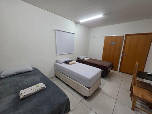 a small room with two beds and a chalkboard at Suítes Caminho do Pantanal in Aquidauana
