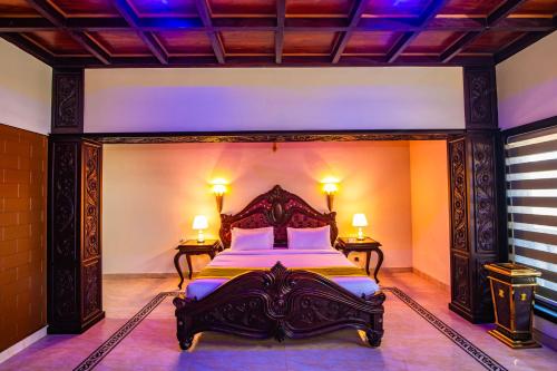 a bedroom with a large bed with two lamps at Clifinn Wellness Beach Resort by nutmeg in Trivandrum