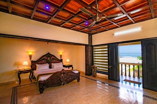 a bedroom with a bed and a view of the ocean at Clifinn Wellness Beach Resort by nutmeg in Trivandrum