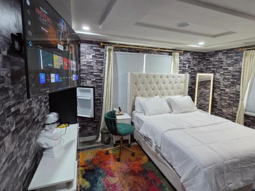a bedroom with a bed and a desk and a tv at Berwyn Alimot Proshortlet-home LLC in Syracuse