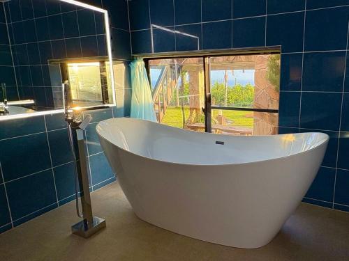 a bath tub in a blue bathroom with a window at Green Post - Vacation STAY 21855v in Yaene