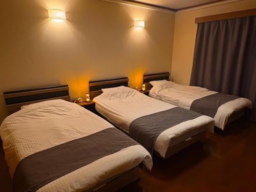 two beds in a hotel room with lights on the wall at Green Post - Vacation STAY 21855v in Yaene