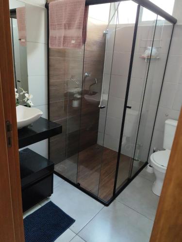 a bathroom with a shower with a sink and a toilet at Apartamento Moderno e Confortável in Lavras