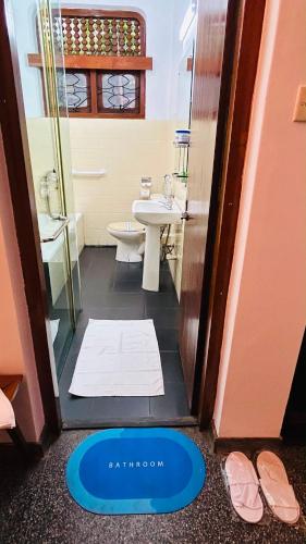 a bathroom with a toilet and a sink and a doorway at Royal Eco Lodge in Kandy