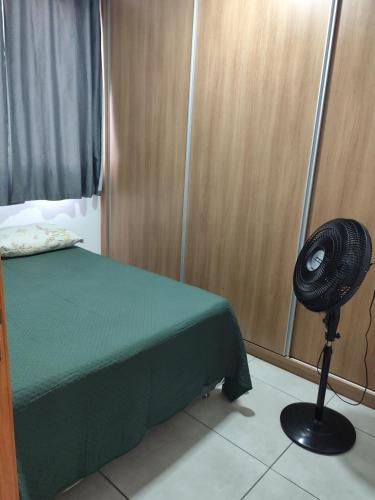 a bedroom with a fan next to a bed at Apartamento Moderno e Confortável in Lavras