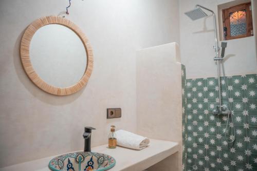 a bathroom with a sink and a mirror and a shower at Ijoukak Berber HomeStay in Ijjoukak