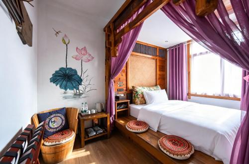 a bedroom with a bed and a window with purple curtains at Windmoon Hillcourt Tianmen Vis Lodge in Zhangjiajie